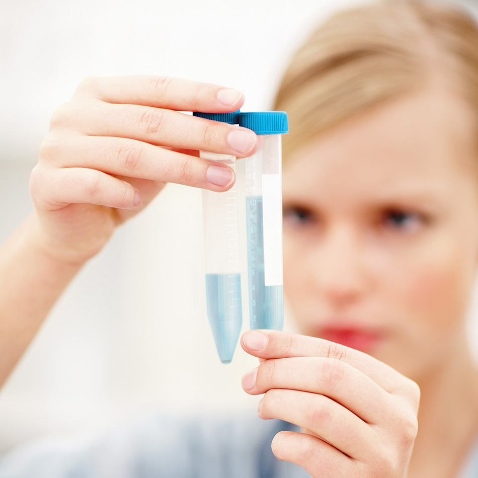 Blurred image of young lady doctor examining vials